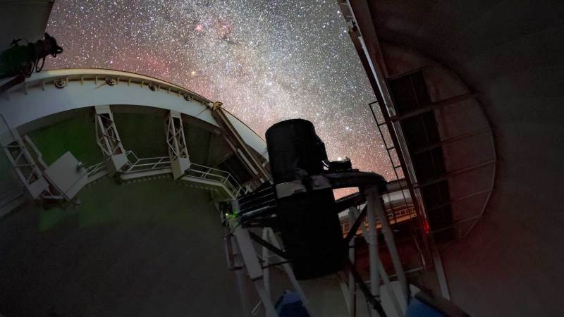 A telescope instrument is pointed at a starry sky.